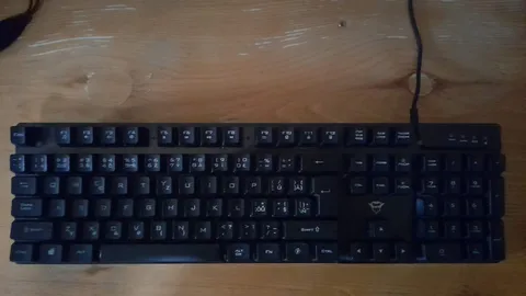 Full-size black keyboard on a wooden desk