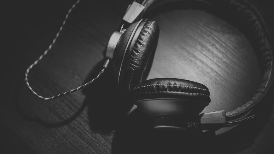 Black-and-white photo of closed-back headphones resting on a surface