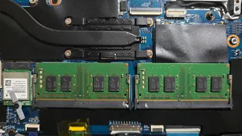 Open laptop showing two memory modules installed next to the cooling pipes