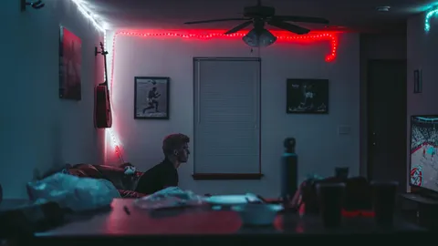 Room lit by a red LED strip along the ceiling, with a person at a desk