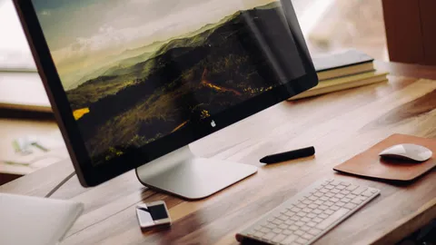 Large monitor on a wooden desk with a keyboard and mouse in front of it