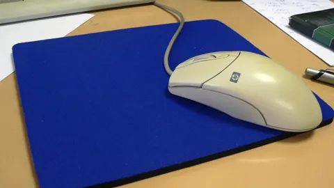 Wired mouse on a blue cloth mouse pad on a desk