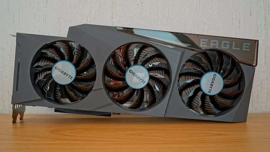 Gigabyte GeForce RTX 3090 Eagle graphics card with three fans, standing on a wooden desk