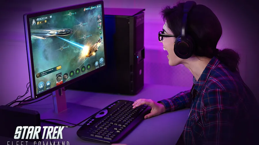Player wearing a headset playing Star Trek Fleet Command on a desktop PC with purple lighting