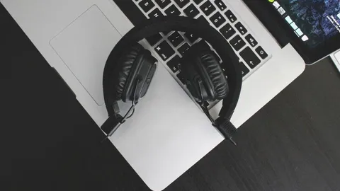 Black over-ear headphones resting on a laptop keyboard